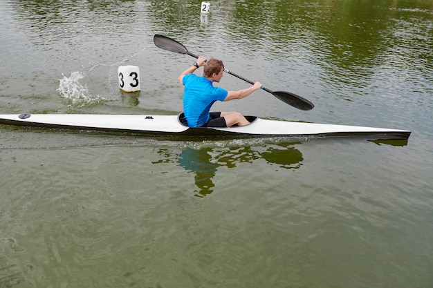 Joven deportista remando en una canoa