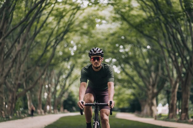 Joven deportivo con bicicleta negra para andar en bicicleta al aire libre