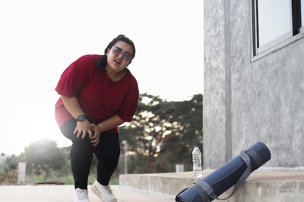 Joven deportivo delgado asia mujer entrenador internet video entrenamiento en línea hatha yoga instructor moderno portátil pantalla meditar Sukhasana postura relajarse respirar fácil asiento pose gimnasio estilo de vida saludable concepto.