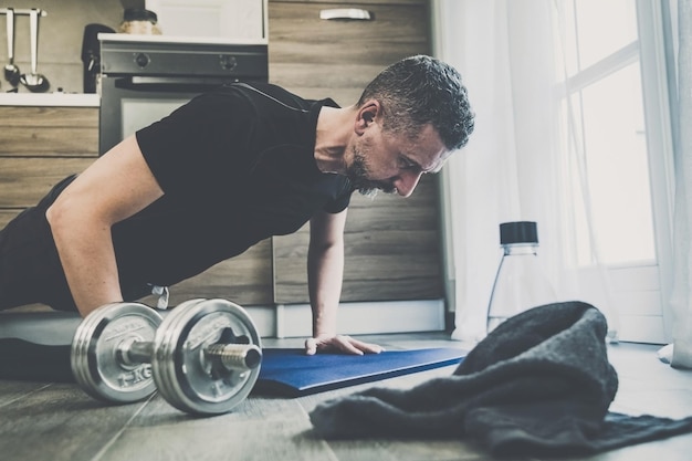 Joven deportivo haciendo ejercicio y entrenando en casa niño en forma haciendo flexiones ejercicios de salud gimnasio deportivo