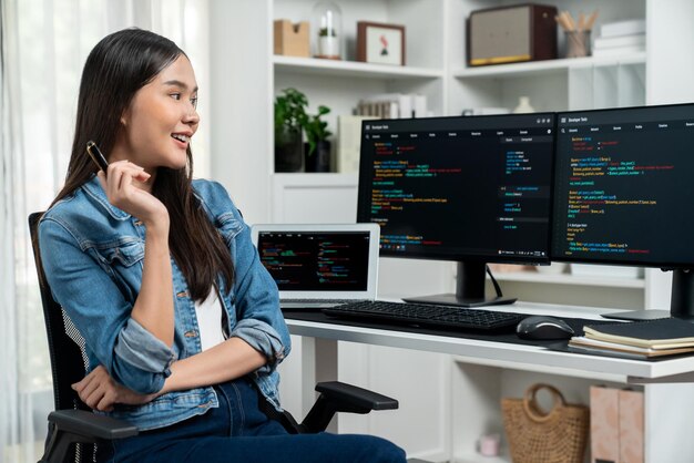Joven desarrollador asiático en busca de información en línea en la PC para plantear estratagemas