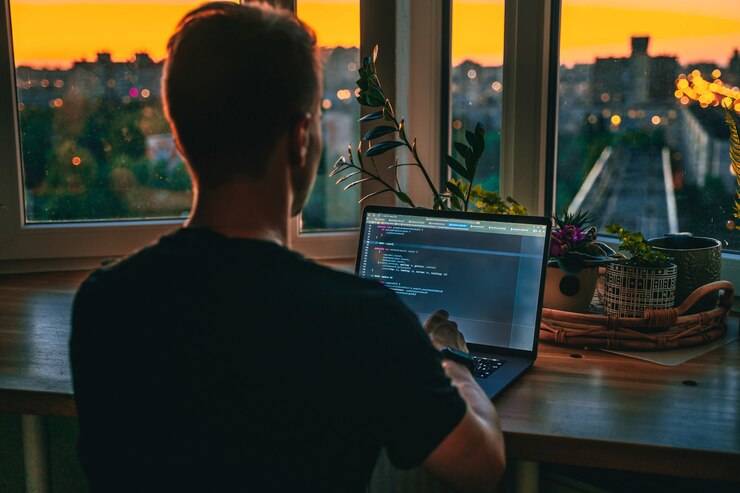 Foto un joven desarrollador está programando un guión de código tarde en la noche con hermosas luces de la ciudad