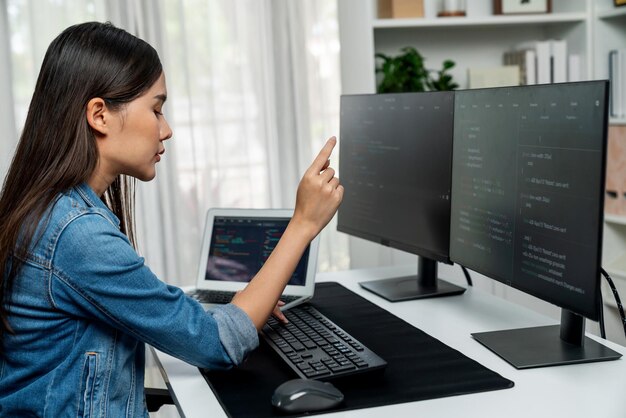 Joven desarrollador de TI asiático que señala información en línea en PC Stratagem