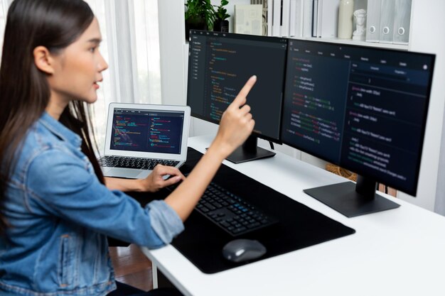 Joven desarrollador de TI asiático que señala información en línea en PC Stratagem