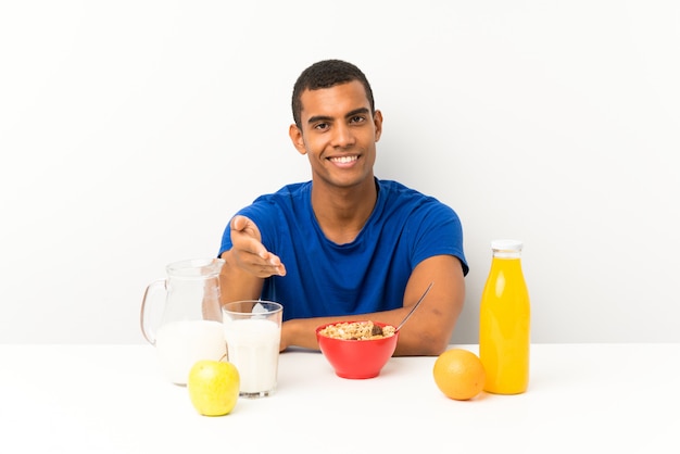 Joven desayunando en una mesa de apretón de manos