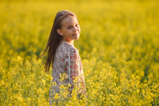 Joven despreocupada disfruta del atardecer en un campo