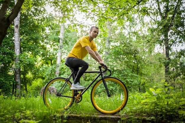 Un joven se detuvo a descansar con su bicicleta en un parque público