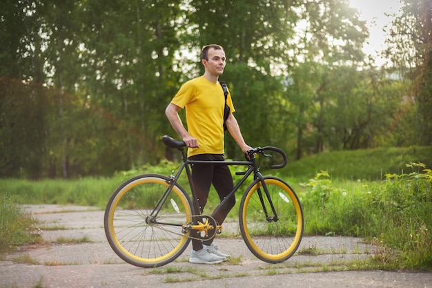 Un joven se detuvo a descansar con su bicicleta en un parque público