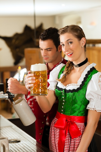 Joven dibujando cerveza en restaurante o pub