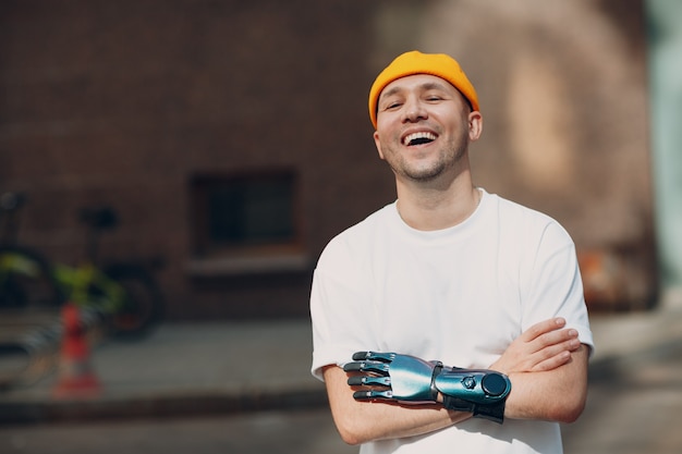 Joven discapacitado riendo con prótesis artificial retrato de mano cruzada