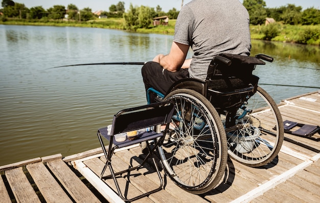 Joven discapacitado en silla de ruedas pescando