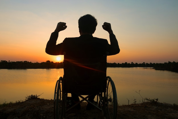 Joven discapacitado silueta viendo río