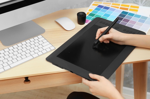 Joven diseñador dibujando bocetos en tableta gráfica