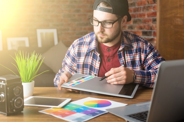 Foto joven diseñador de perspectiva con tableta gráfica en la oficina moderna