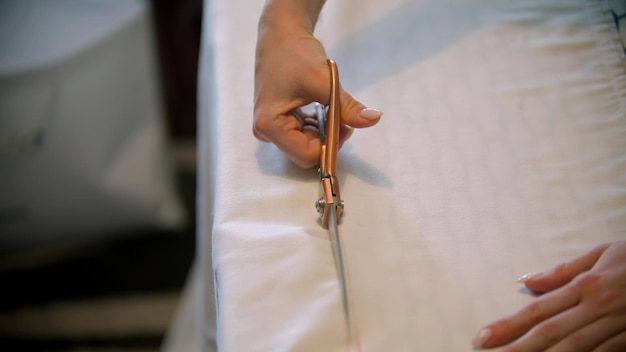 Joven diseñadora cortando un paño blanco