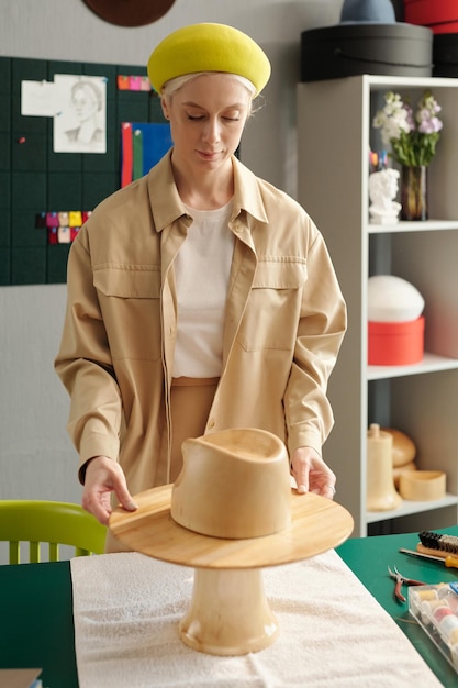 Foto joven diseñadora creativa de sombreros preparando piezas de madera