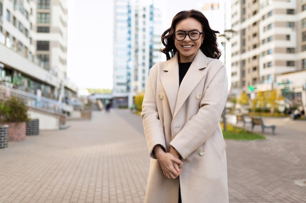 Joven diseñadora europea sonriente en el fondo de una calle de la ciudad