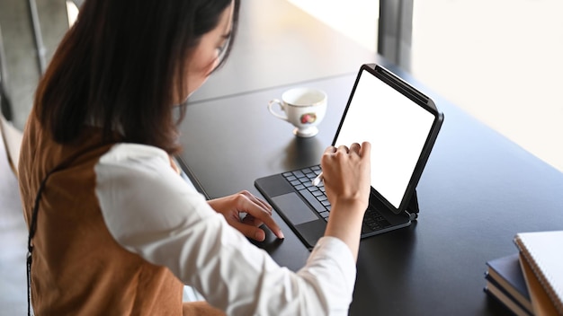 Joven diseñadora sosteniendo lápiz óptico dibujo en tableta digital en el lugar de trabajo moderno.