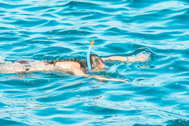 la joven disfruta buceando en el mar azul