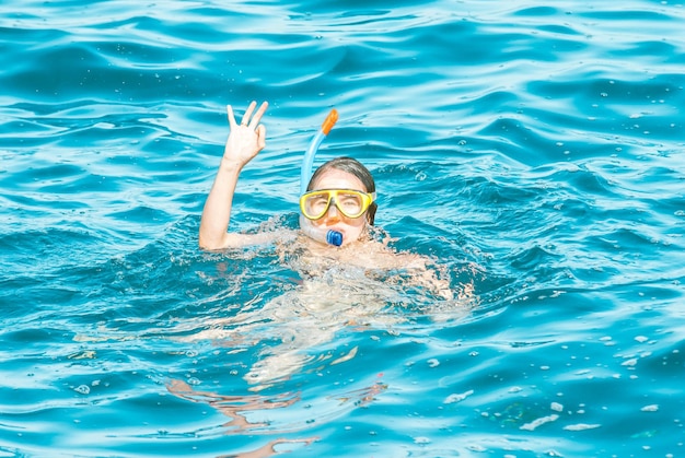 la joven disfruta buceando en el mar azul