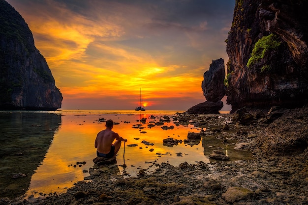 Joven disfruta de una espectacular puesta de sol en maya beach en tailandia