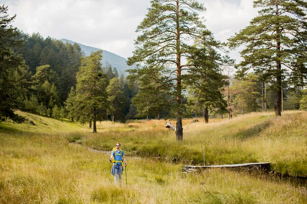 Joven disfruta de ir de excursión en un día soleado