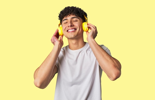 Foto un joven disfruta de sus canciones favoritas con sonido de alta calidad usando auriculares inalámbricos