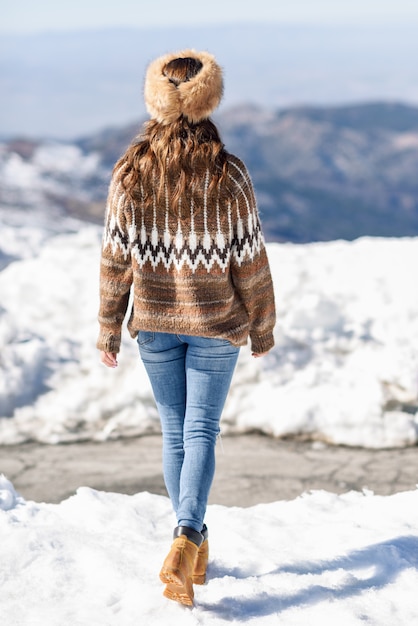 Joven disfrutando de las montañas nevadas en invierno