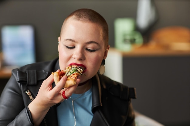 Una joven disfrutando de la pizza.