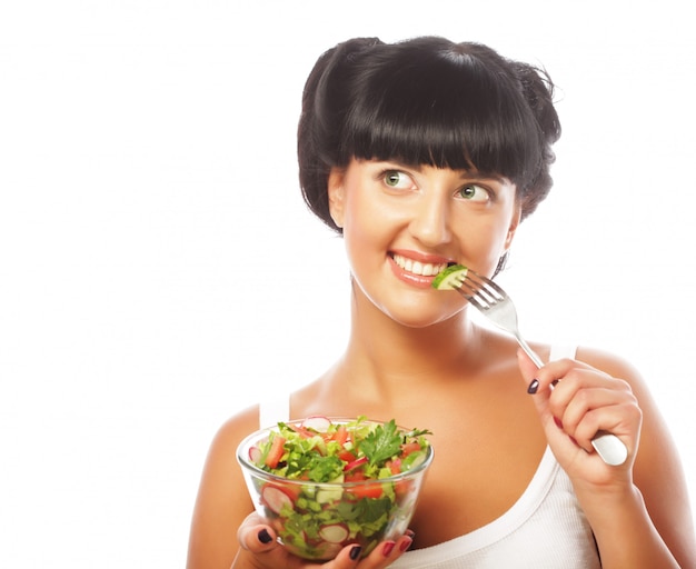 Joven divertida comiendo ensalada