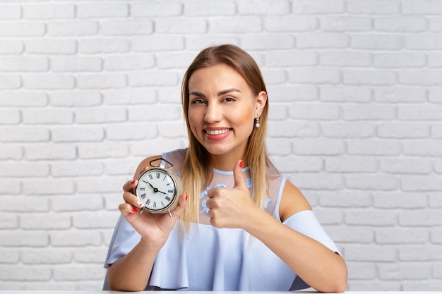 Joven divertida con reloj despertador