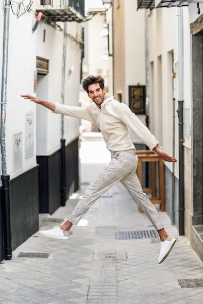 Joven divertido saltando en la calle.