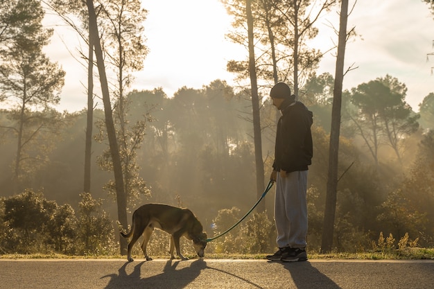 Joven divirtiéndose con su perro en la naturaleza con los rayos del sol de la mañana amo a mi perro