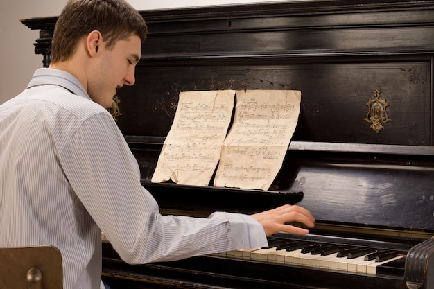 Joven divirtiéndose tocando el piano