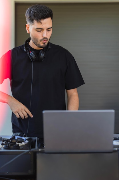 El joven DJ con la computadora portátil feliz con el resultado de su nueva canción