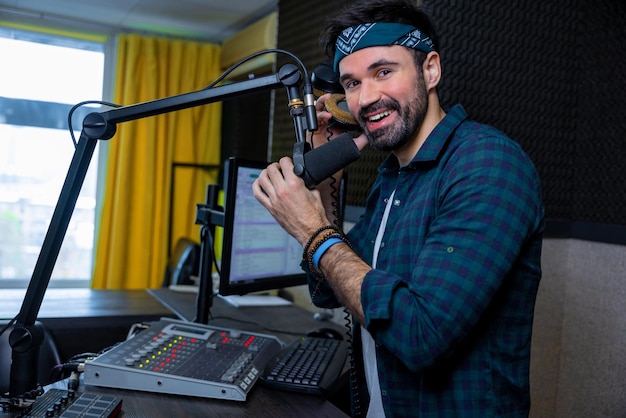 Joven dj de pelo oscuro que parece contento en el estudio