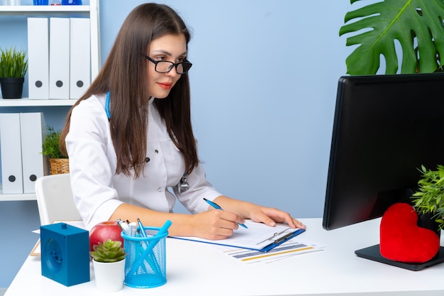 Foto joven doctora agradable trabajando en su oficina