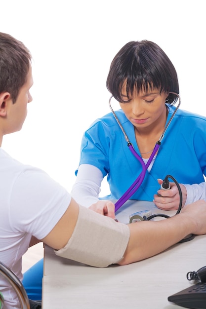 Joven doctora asiática midiendo la presión arterial