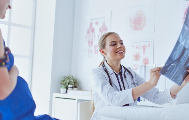 Joven doctora atractiva mirando la imagen de rayos x.