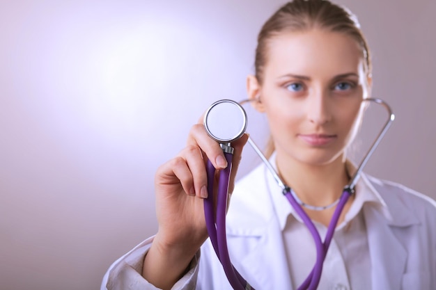 Foto una joven doctora escuchando sosteniendo un estetoscopio médico