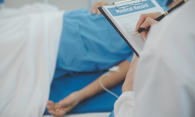 Joven doctora está usando un estetoscopio para escuchar los latidos del corazón del paciente Toma de una doctora dándole un chequeo a un paciente varón