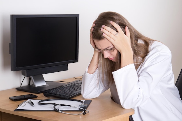 Foto una joven doctora estresada sentada en su oficina