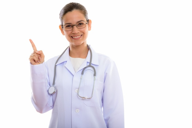 Joven doctora feliz sonriendo mientras apunta el dedo hacia arriba