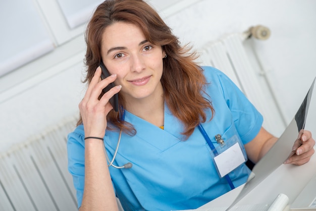 Joven doctora hablando por teléfono