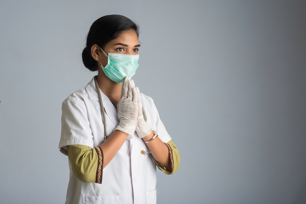 Joven doctora haciendo Namaste debido al brote de COVID-19. Nuevo saludo para evitar la propagación del coronavirus en lugar de saludar con un abrazo o un apretón de manos.