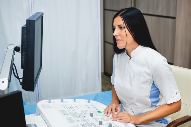 Joven doctora hermosa mira los resultados de la ecografía en la clínica