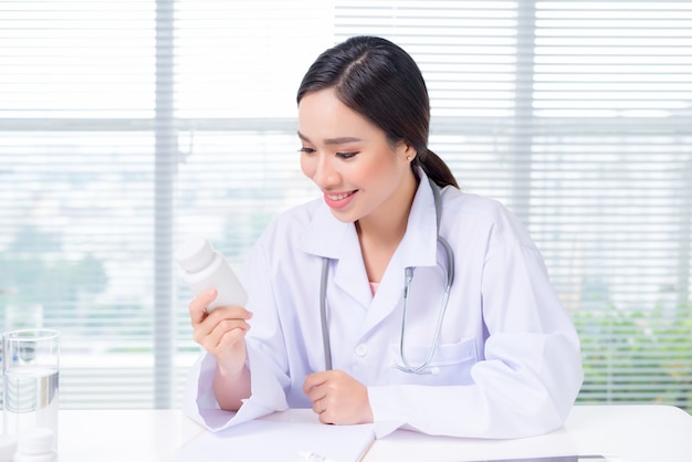 Joven doctora mirando concentrado mientras está sentado en la mesa