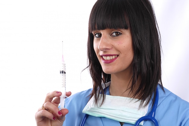 Joven doctora sonriente con jeringa en blanco