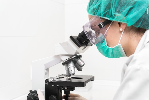 Joven doctora trabajando con un microscopio en un laboratorio