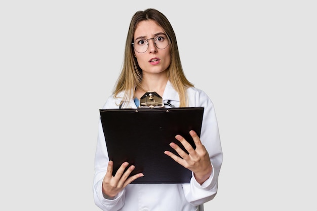 Joven doctora en uniforme leyendo archivos aislados